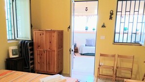 A bedroom with a bed, wooden wardrobe, and a desk. - Castro: House with private access to the sea (Castro)