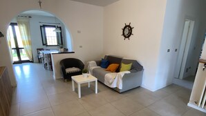A spacious living area with a sofa, a small table, and a dining area in the background. - Villa Lido di Spina "Adriatic coast" (Lido di Spina)