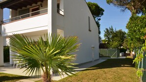 A white two-story house with a balcony, a lawn, and a palm tree. - Villa Lido di Spina "Adriatic coast" (Lido di Spina)