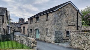 En byggnad av sten med en traditionell arkitektonisk stil, kännetecknad av ett brant tak och ett litet torn med en klocka.