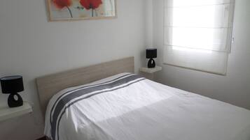 1 dormitorio, tabla de planchar con plancha, ropa de cama