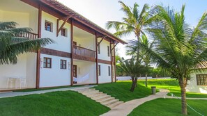 A two-story building with a balcony, surrounded by well-maintained grass and palm trees. - Acquapipa Resort (Tibau do Sul)