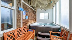 A spa area with wooden benches, a hot tub, and a wooden wall with a sign. - Whitewater Ocean View, Spa, Secret Game Room, 800 SF Master Suite (Newport)