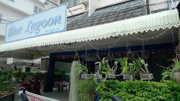 A Blue Lagoon bar with a sign, outdoor seating, and potted plants. - Blue Lagoon Guest House and Bar (Cha-am)