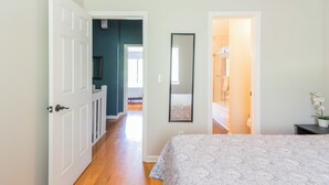 A bedroom with a bed, a door leading to a bathroom, and a hallway.