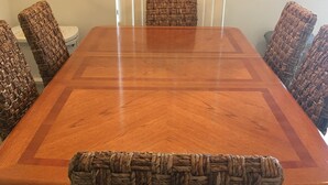 A rectangular wooden dining table with woven chairs.