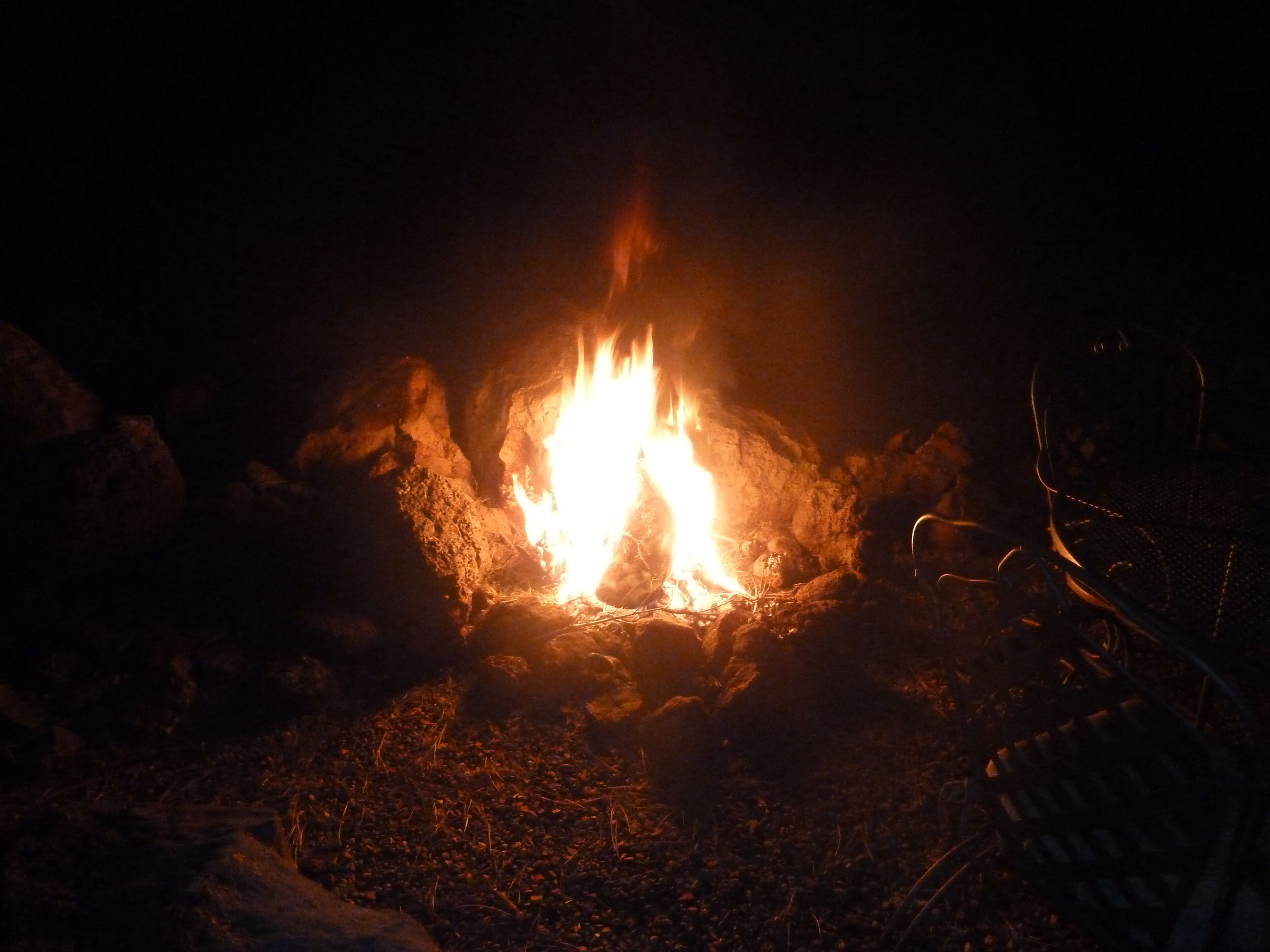 A campfire in a rocky outdoor setting.