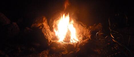 A campfire in a rocky outdoor setting.