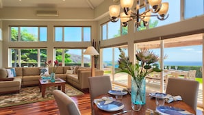 Un salon spacieux avec une grande table à manger, des sièges confortables et une vue sur l’extérieur.