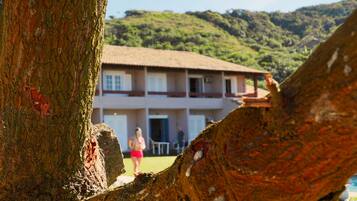Un edificio de dos pisos con un balcón y vistas a un paisaje montañoso.
