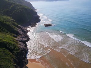 En la playa, arena blanca, sombrillas, toallas de playa
