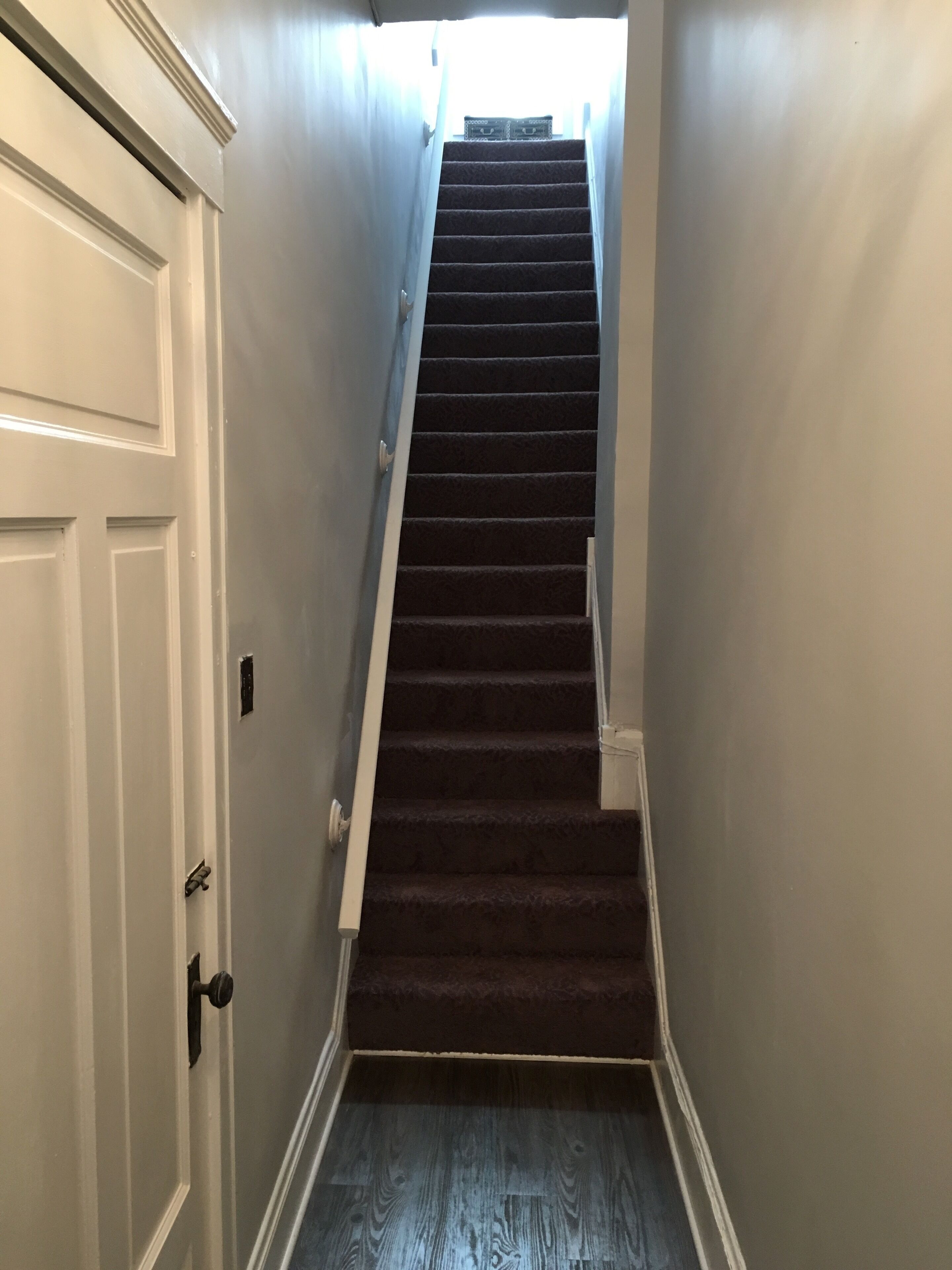 A staircase with a carpeted floor leading to a landing.