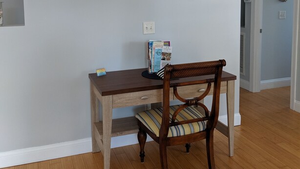 A dining area with a wooden table and chair, a wall-mounted anchor decoration, and a staircase with a fish figurine. - 1ST STREET II BEACH HOUSE, UPDATED DOG FRIENDLY  FENCED IN YARD 1 BLOCK TO BEACH (St. Augustine)