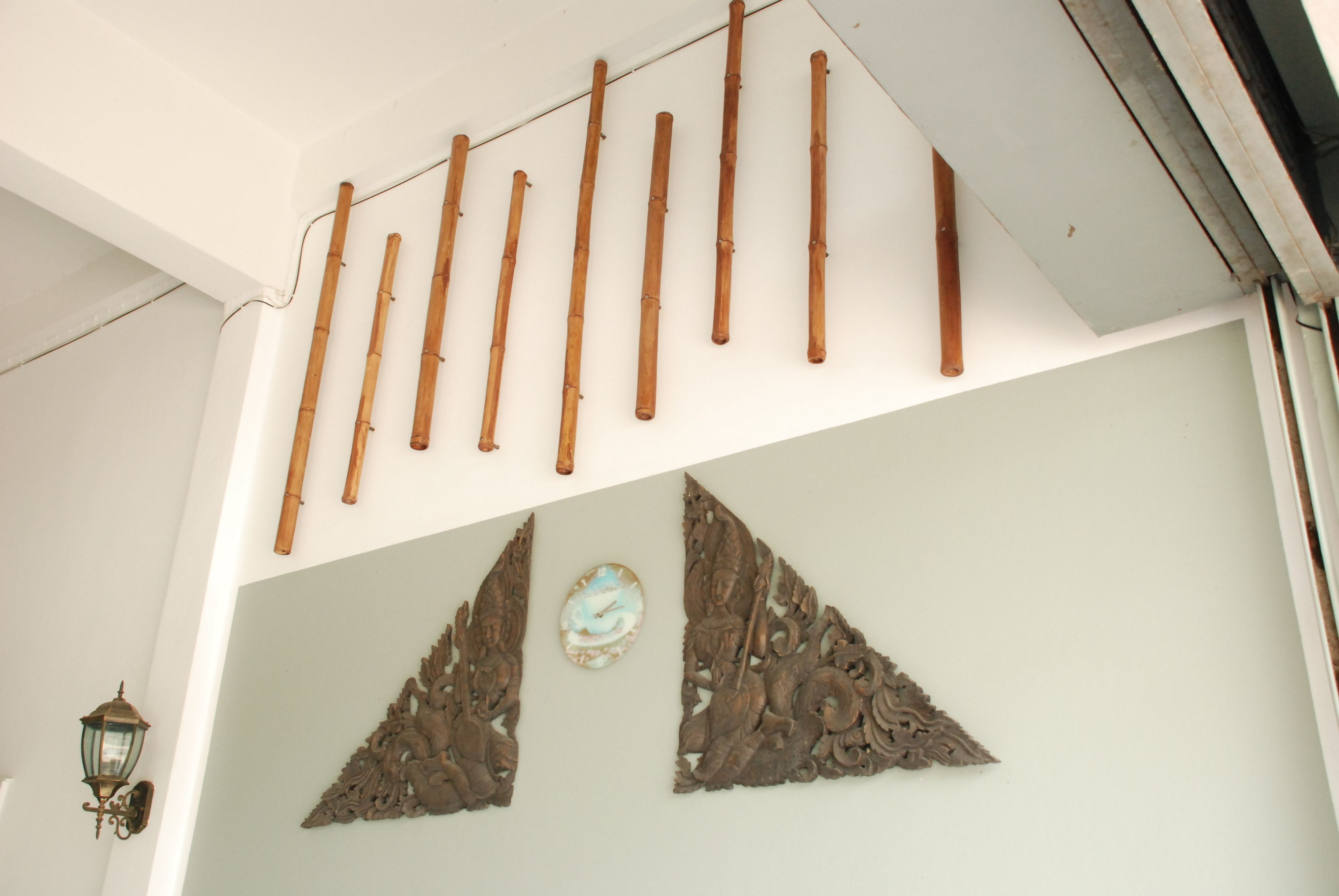 A ceiling with bamboo rods and decorative wall art.