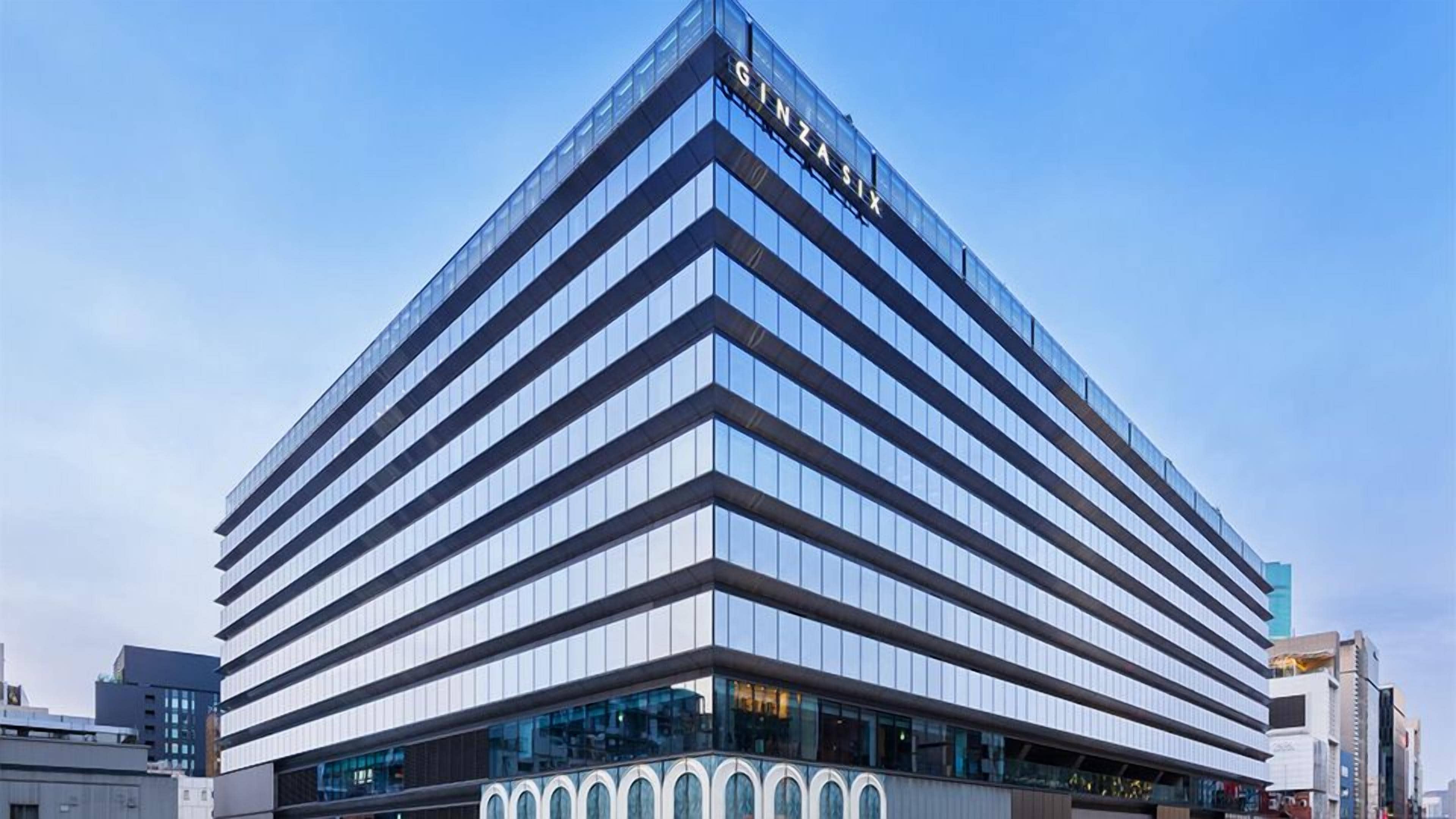 Ein modernes, mehrstöckiges Gebäude mit einem auffälligen 'GINZA SIX'-Schild oben.