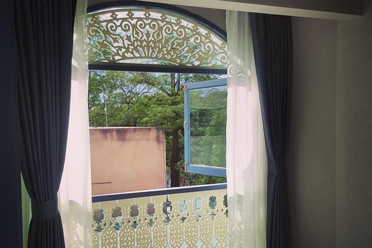 Ein Schlafzimmer mit Balkon, einem Bett und Blick auf Grün.