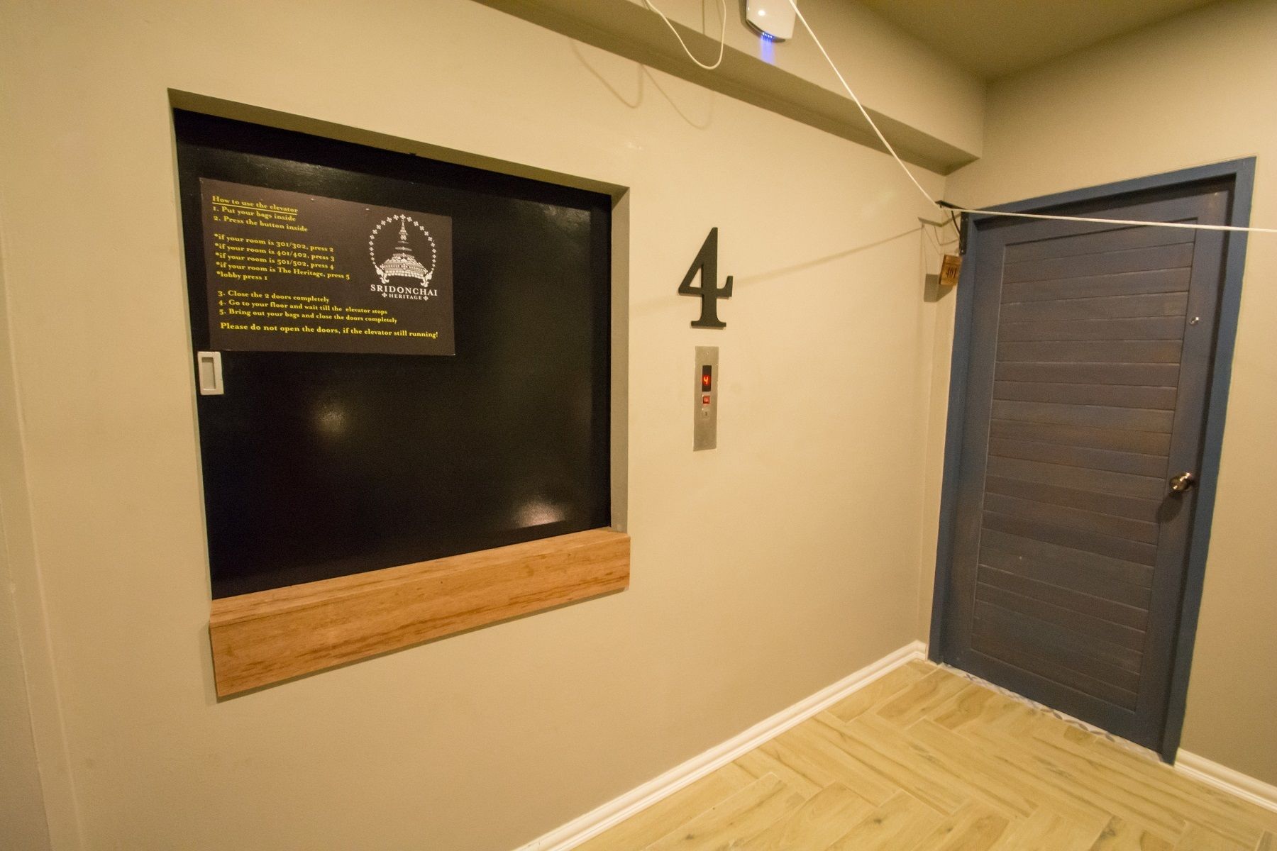 A hallway with a door marked '4', a sign with instructions, and a small window.