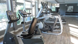 A gym with stationary bikes, treadmills, and a wall of dumbbells. - Baan Thew Lom By Woranan (Cha-am)