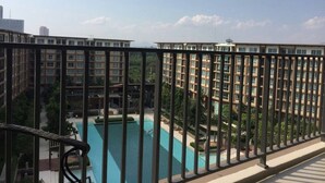 A residential building with a swimming pool and a view of other buildings. - Baan Thew Lom By Woranan (Cha-am)