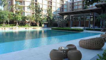 A swimming pool with lounge chairs and a building in the background.