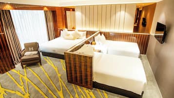 Una habitación de hotel con una cama grande, otra más pequeña, una silla y un espejo.