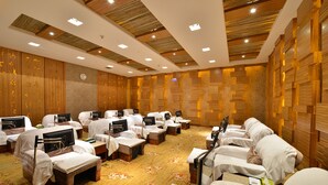 Ein Hotelzimmer mit mehreren Betten, die nebeneinander angeordnet sind, Holzwandverkleidung und einer Wanduhr.