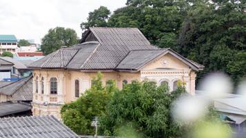 A traditional building with a sloped roof, surrounded by lush greenery.