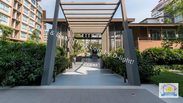 A covered walkway leading to a building entrance, surrounded by greenery and modern architecture. - Baan Thew Lom Cha-Am Huahin by D-light (Cha-am)