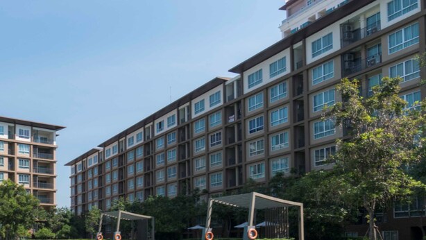 A multi-story building with a modern architectural design, featuring balconies and large windows. - Baan Thew Lom Cha-Am Huahin by D-light (Cha-am)