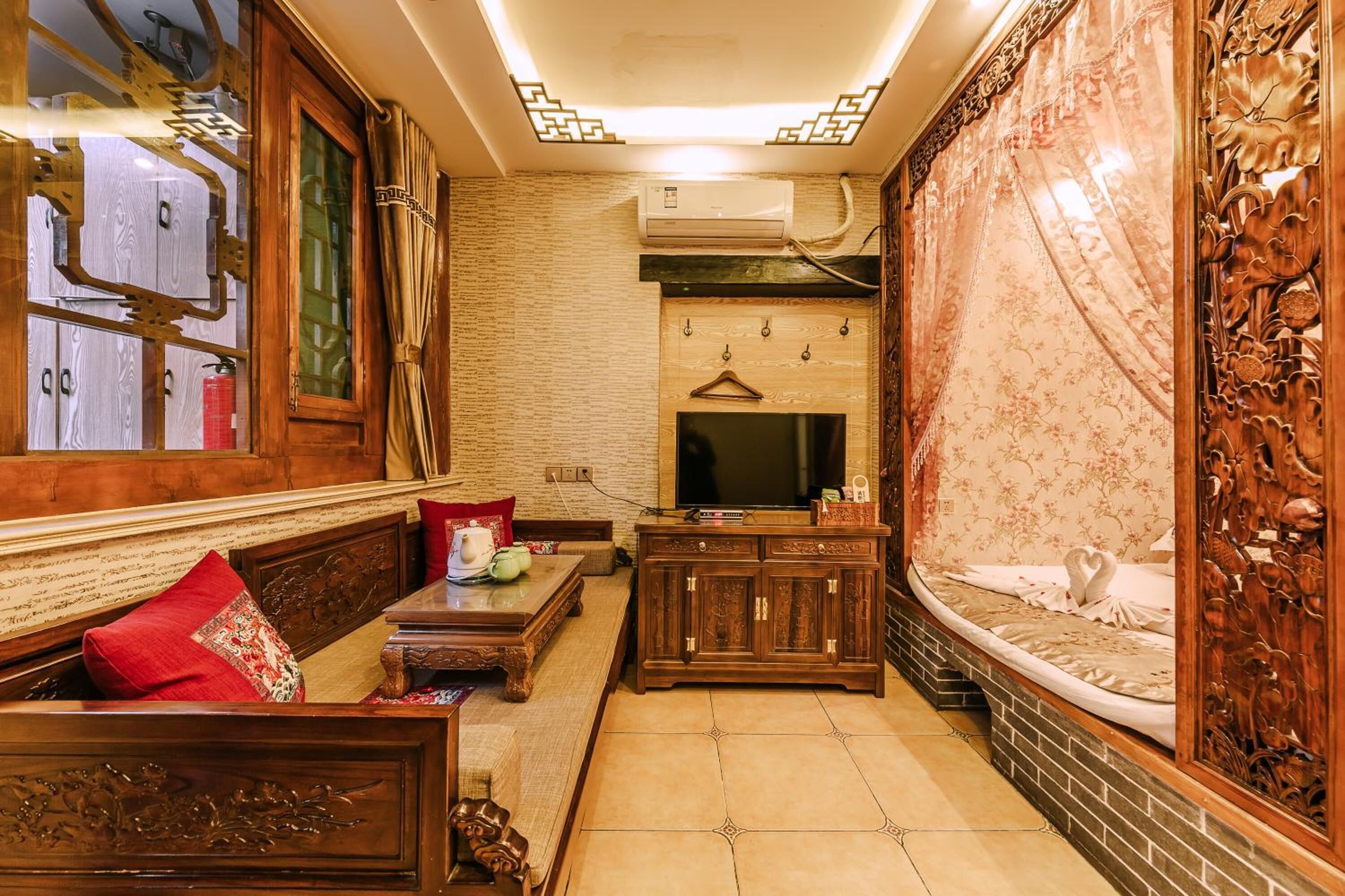 A traditional-style living room with a sofa, a coffee table, a TV, and a decorative cabinet.