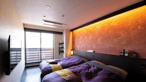 Een moderne hotelkamer met twee bedden, een groot raam en een tv aan de muur.
