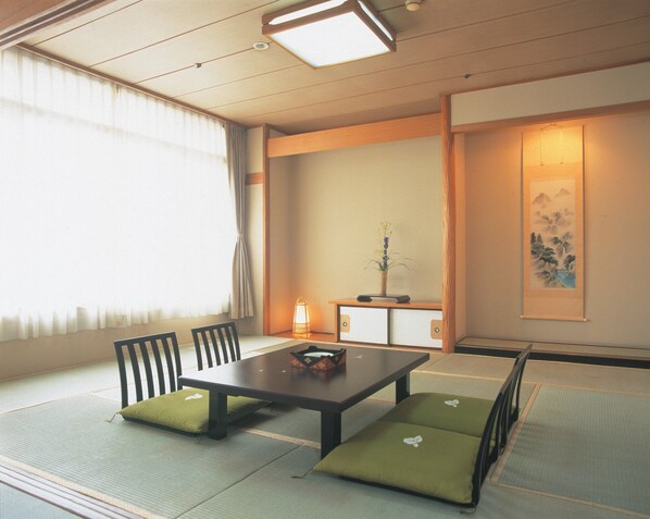 A traditional Japanese tatami room with a low table, chairs, and cushions. - Hanayagi No Sho Keizan (Fuefuki)