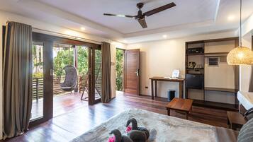 Une chambre d’hôtel moderne dotée d’un grand lit, d’un ventilateur de plafond, d’un coin repas et offrant une vue sur l’extérieur.