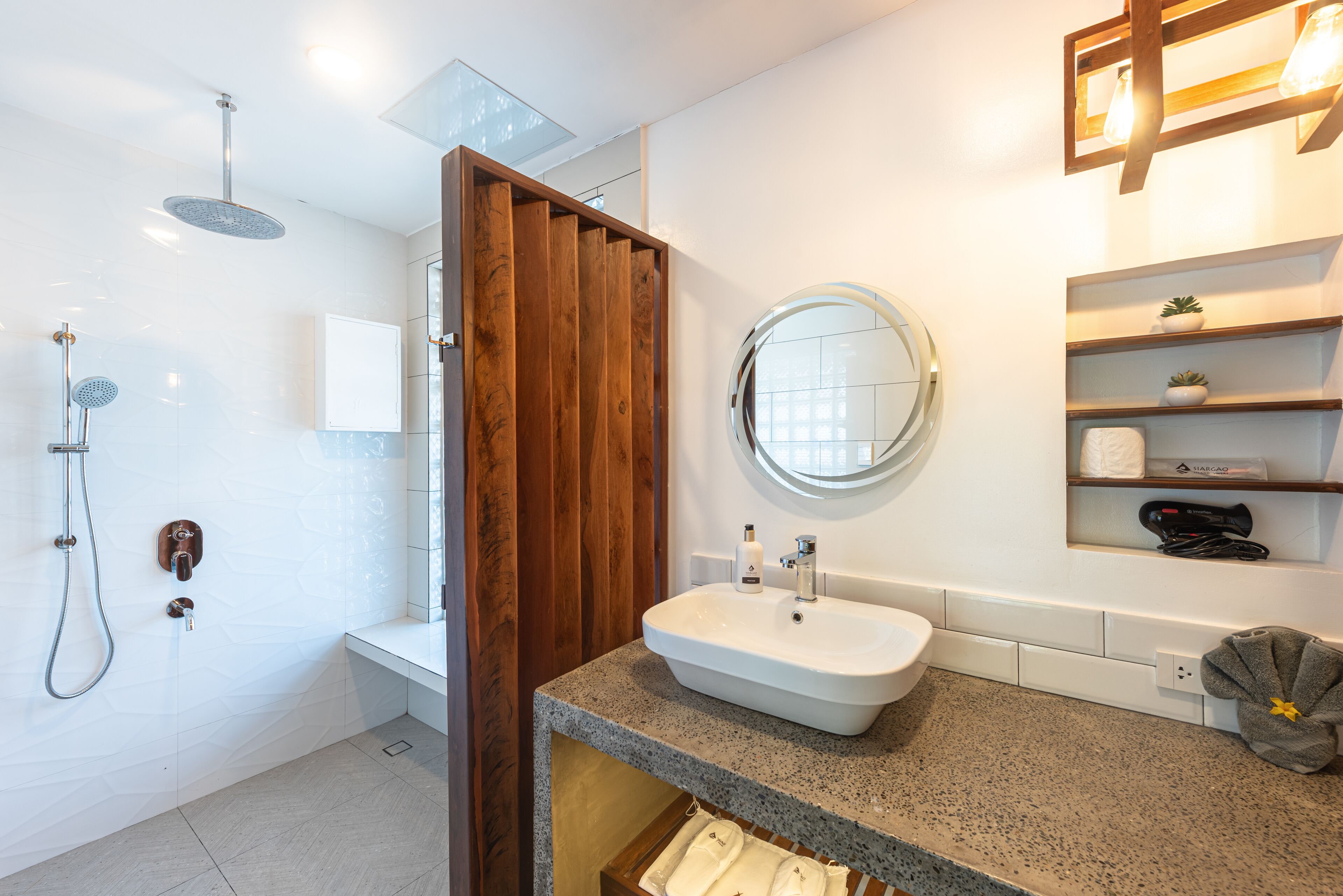 Un baño moderno con ducha, lavamanos y espejo.
