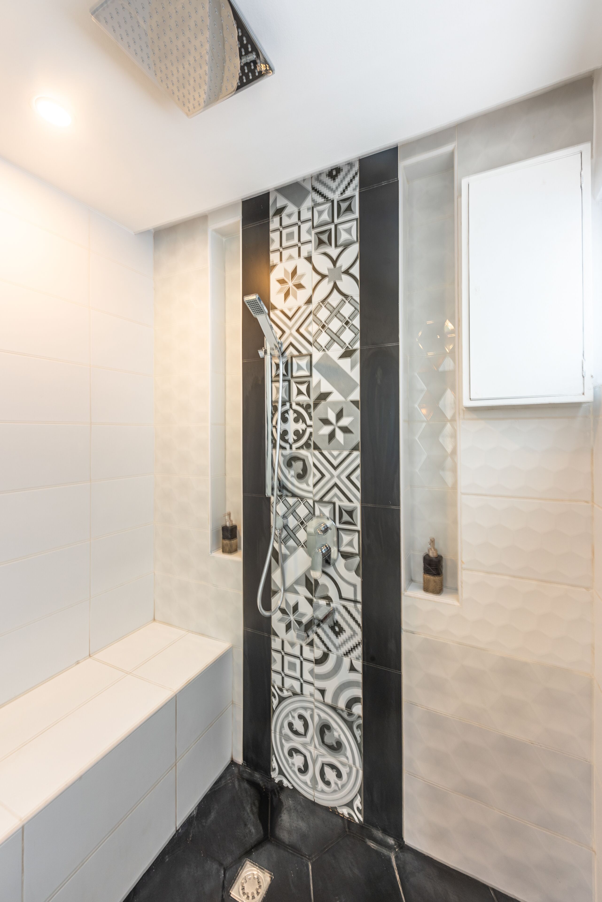 Une salle de bain moderne avec une douche, des carreaux blancs et des panneaux muraux décoratifs.