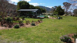A garden with a pool, a gazebo, and a bench. - Valley View Motel (Murrurundi)