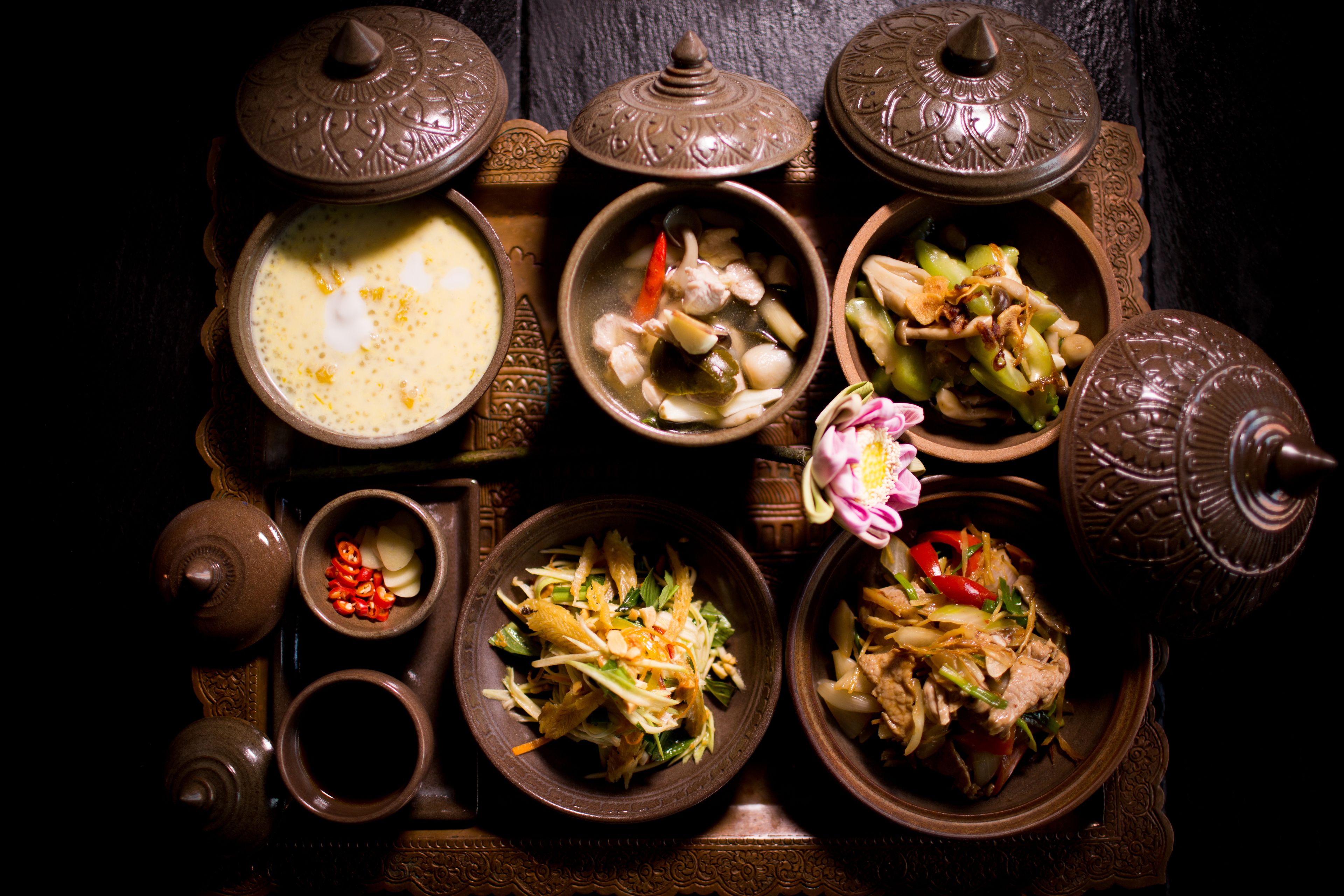 A traditional table setting with various dishes and a teapot.
