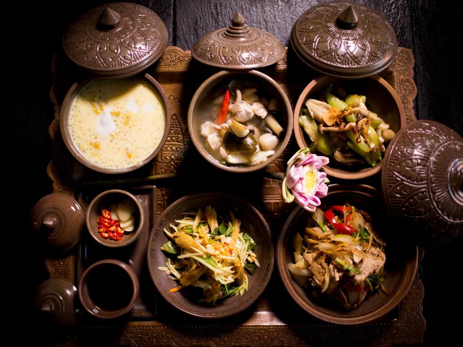 A traditional table setting with various dishes and a teapot.