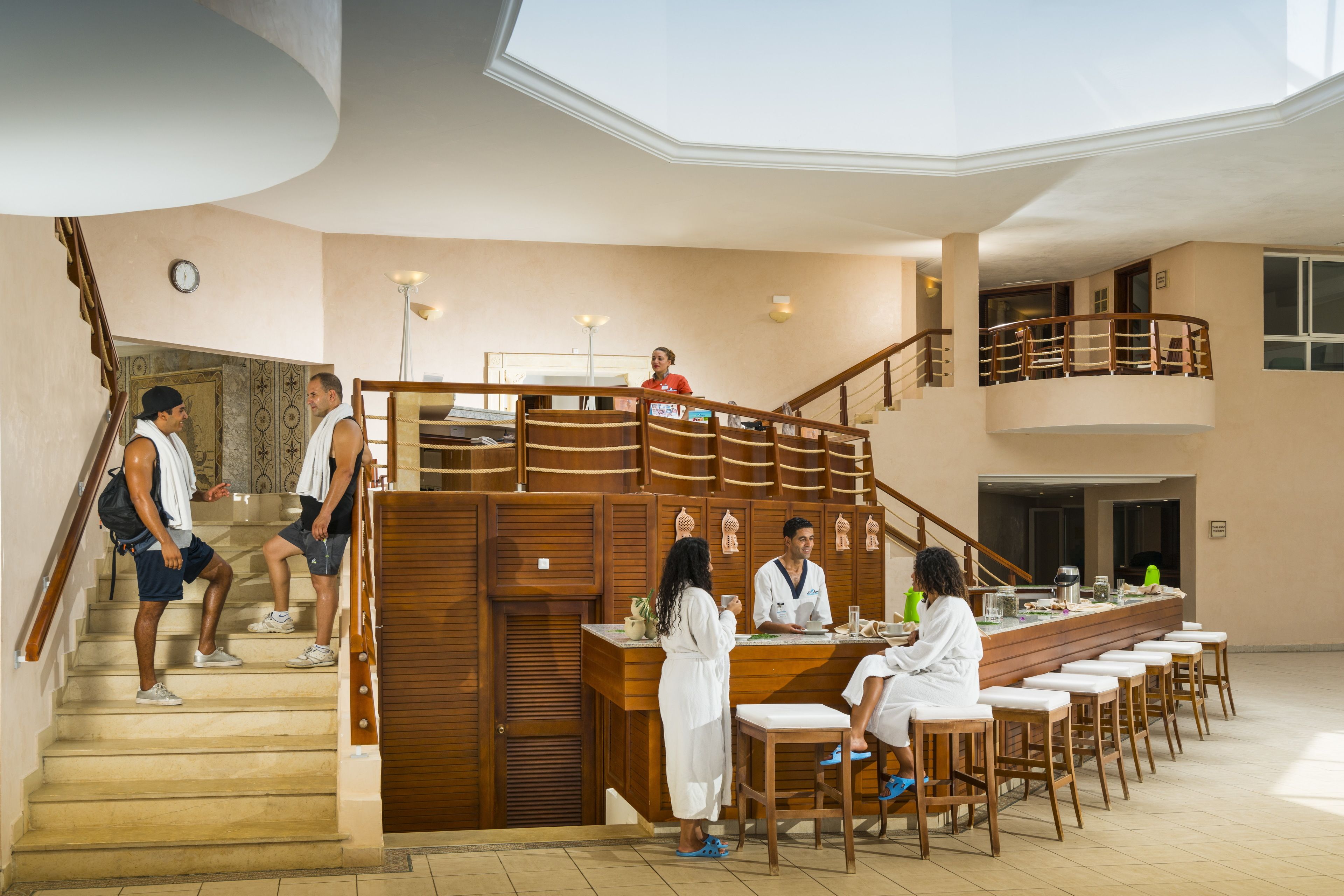 Un hall d’hôtel avec un escalier, un comptoir d’accueil et un espace bar.