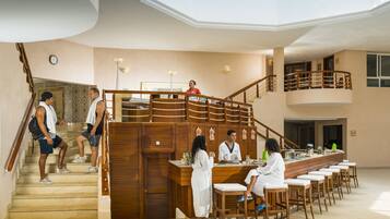 Un hall d’hôtel avec un escalier, un comptoir d’accueil et un espace bar.
