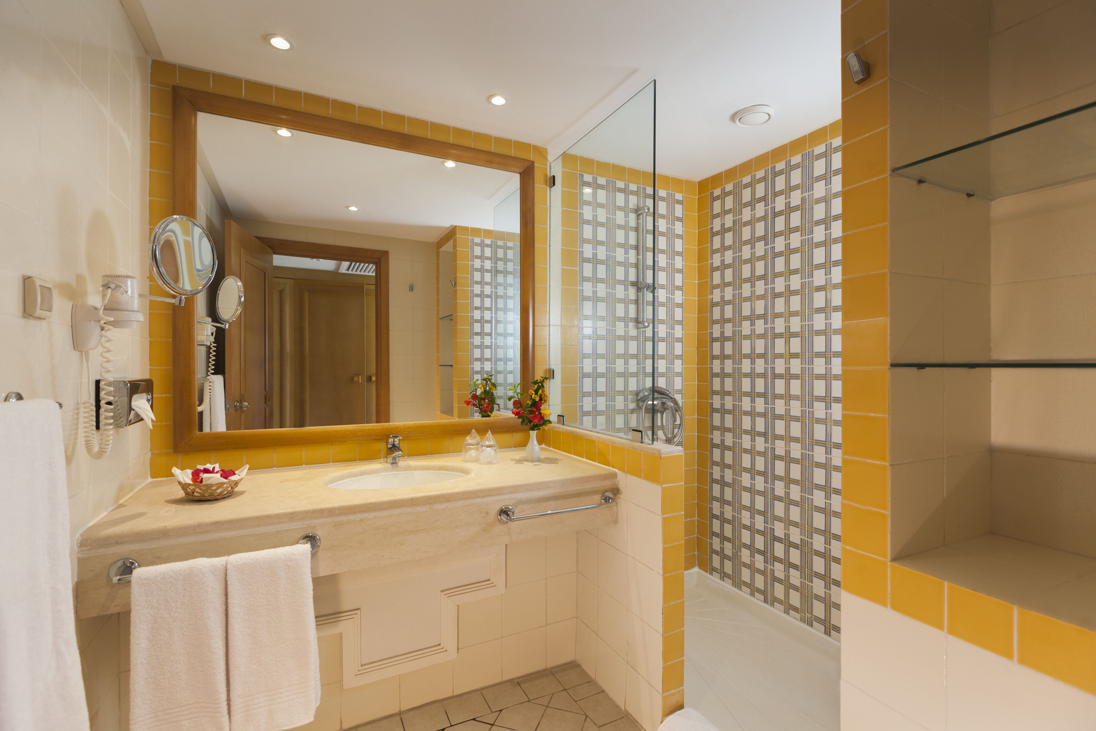 A bathroom with two sinks, a large mirror, and a shower area.