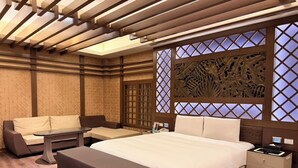 A modern hotel room with a large bed, a sofa, a small table, and a nightstand. - Wei Feng Exquisite Motel Pintung Branch (Pingtung)
