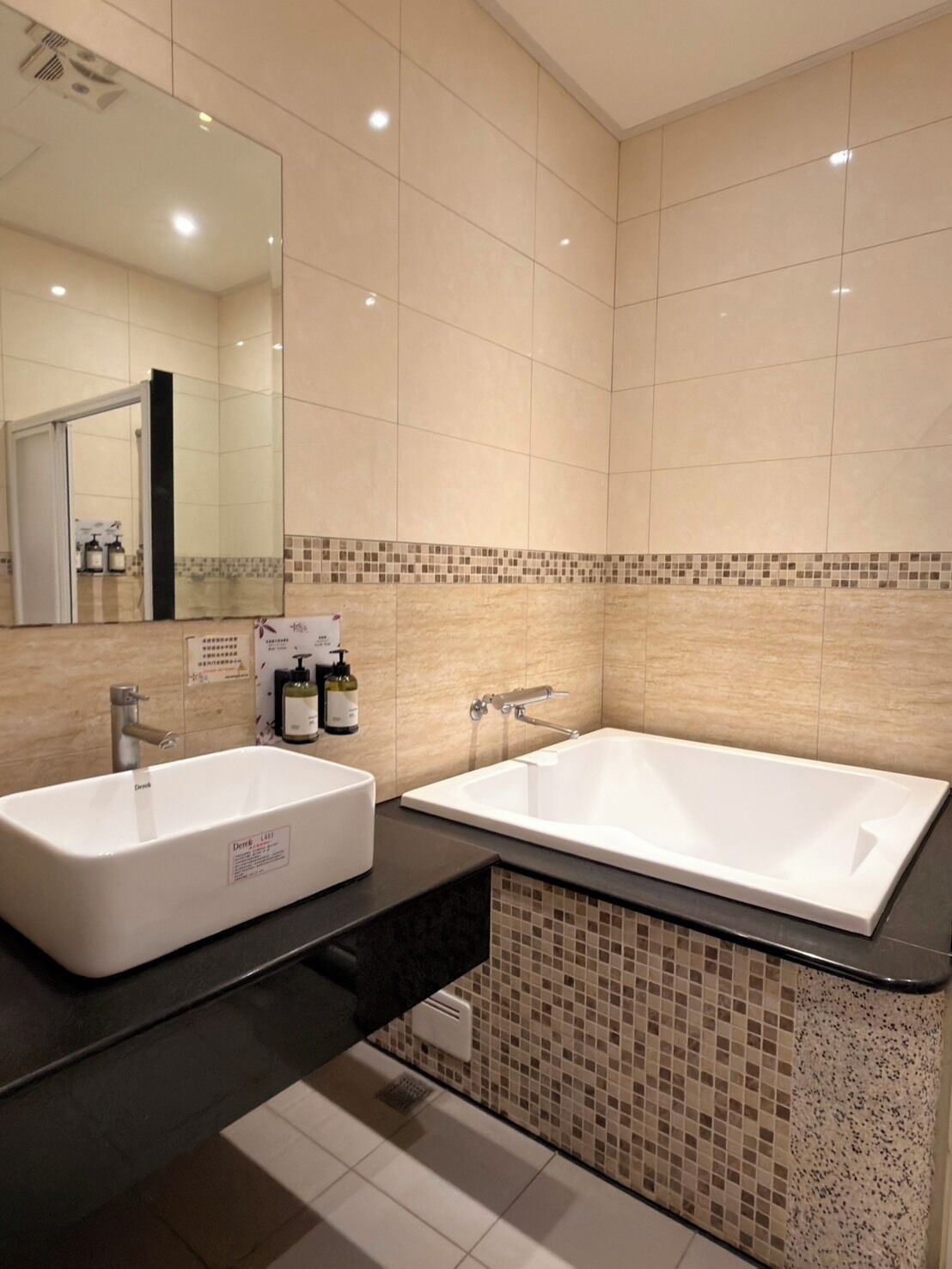 Un baño moderno con una bañera blanca grande, un lavamanos doble y un espejo sobre el lavamanos.