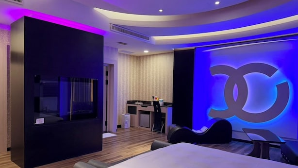 A modern hotel room with a large bed, a vanity with a mirror, a desk, and a seating area. - Wei Feng Exquisite Motel Pintung Branch (Pingtung)