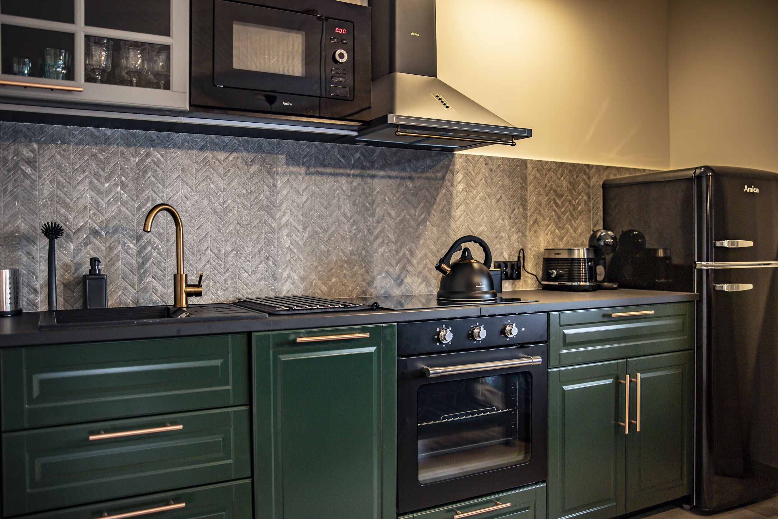 Una cocina equipada con microondas, estufa, horno y refrigerador.