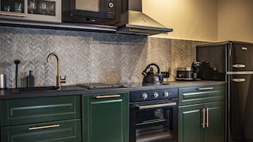Una cocina equipada con microondas, estufa, horno y refrigerador.