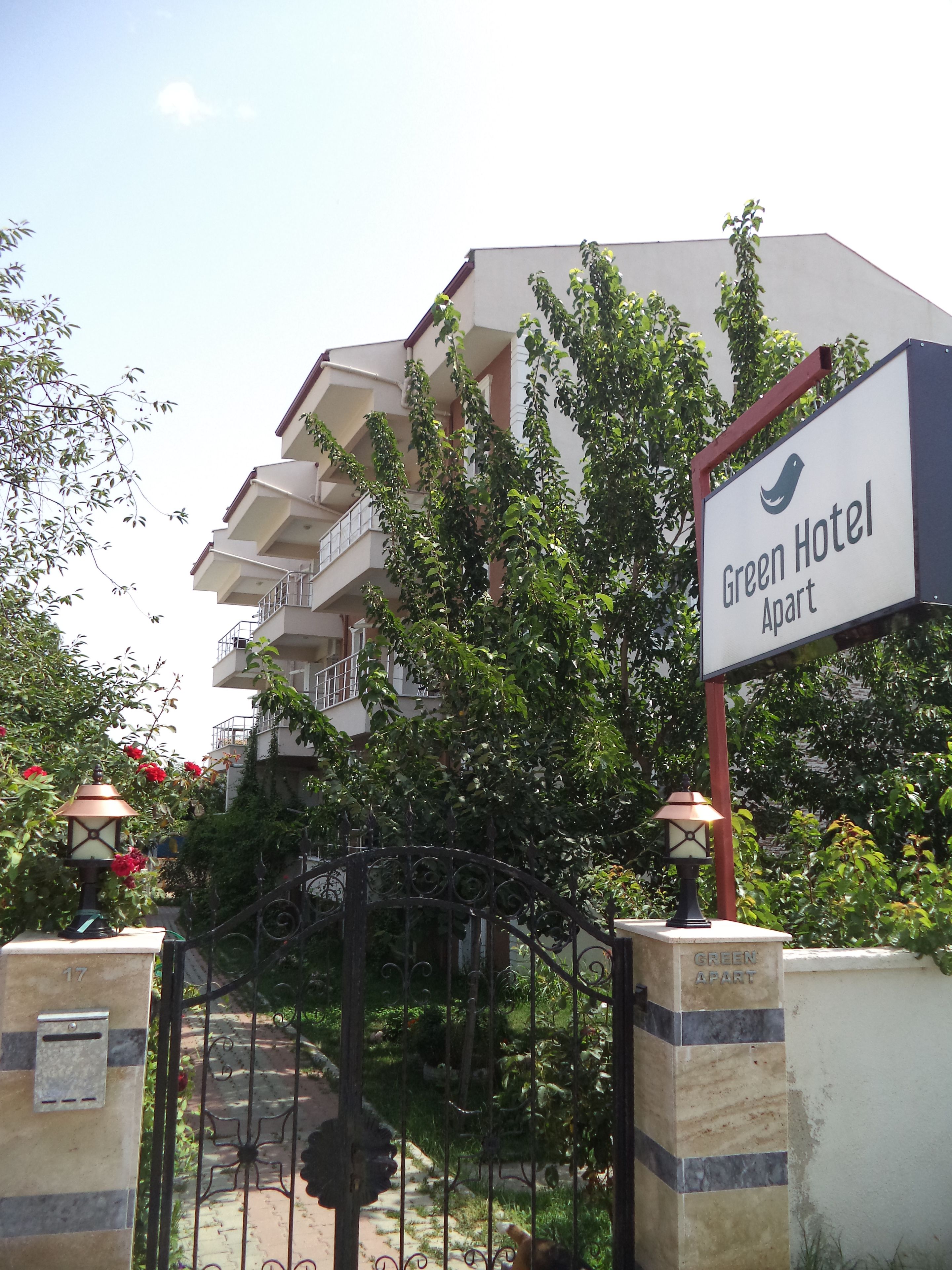 A hotel entrance with a sign reading "Green Hotel Apart".