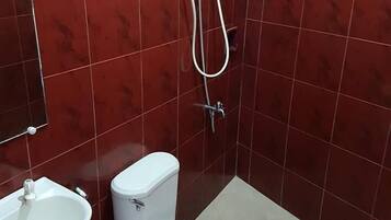 Un baño pequeño con inodoro, lavabo y ducha.