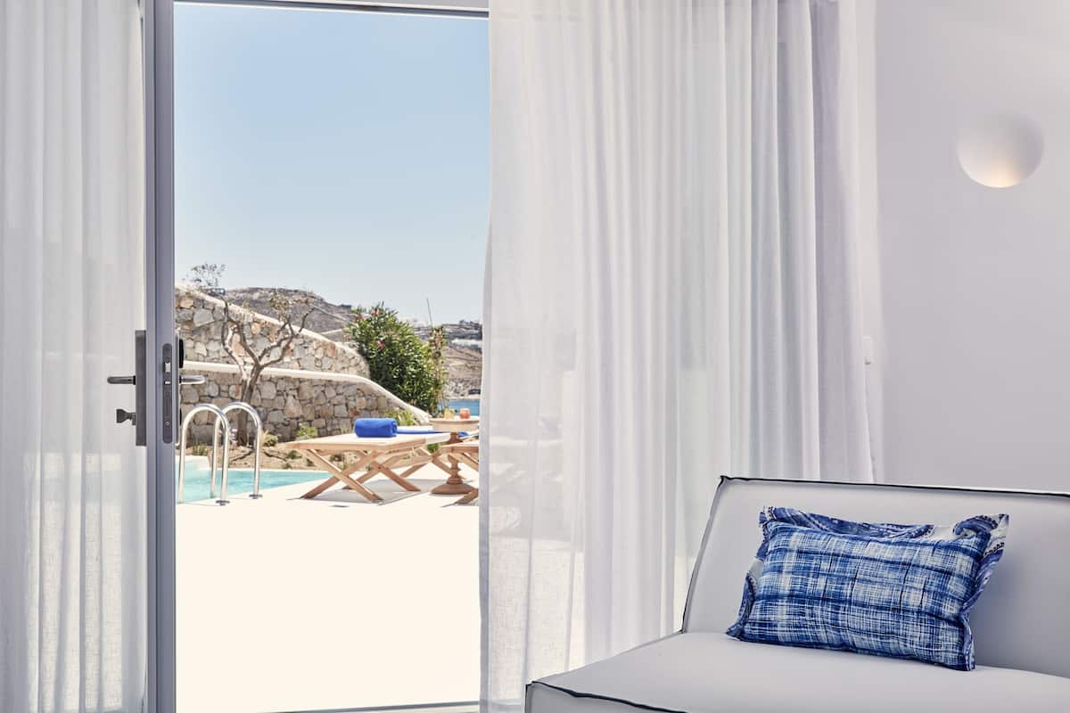 Ein Zimmer mit Blick auf einen Pool und Sitzgelegenheiten im Freien.