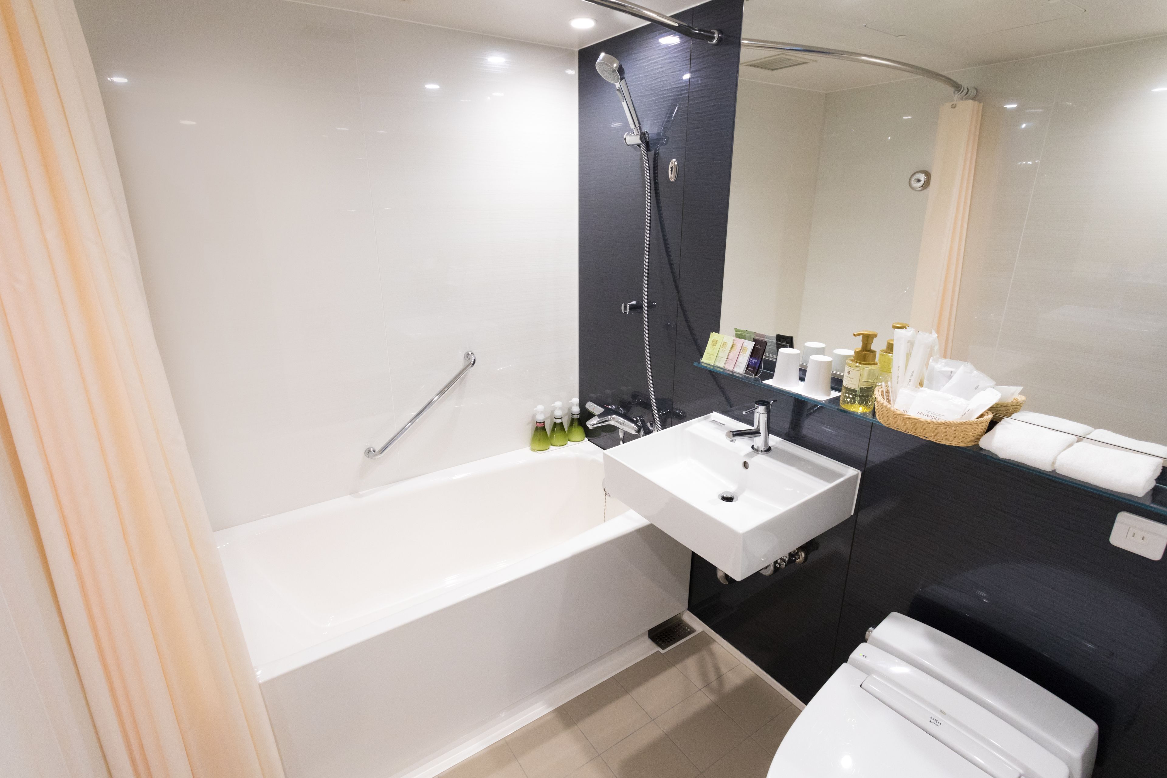Un baño moderno con bañera, lavamanos e inodoro.
